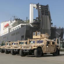 U.S. Marine Corps vehicles are staged for loading onto a ship. (Credit: Sgt. Alize Sotelo, USMC)
